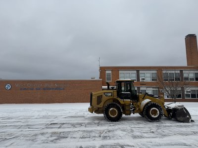 CAT loader clearing snow at the West Orange High School lot.