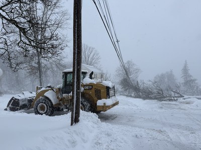 CAT 950 wheel loader working in a heavy snowstorm with downed power lines and trees.