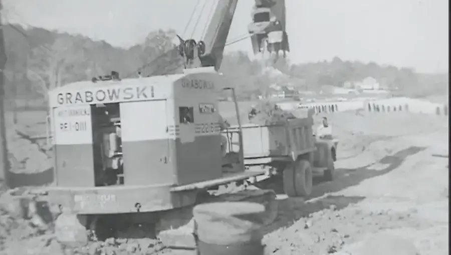 A GRABOWSKI cable shovel and dump truck at a rock-cut sitework job.