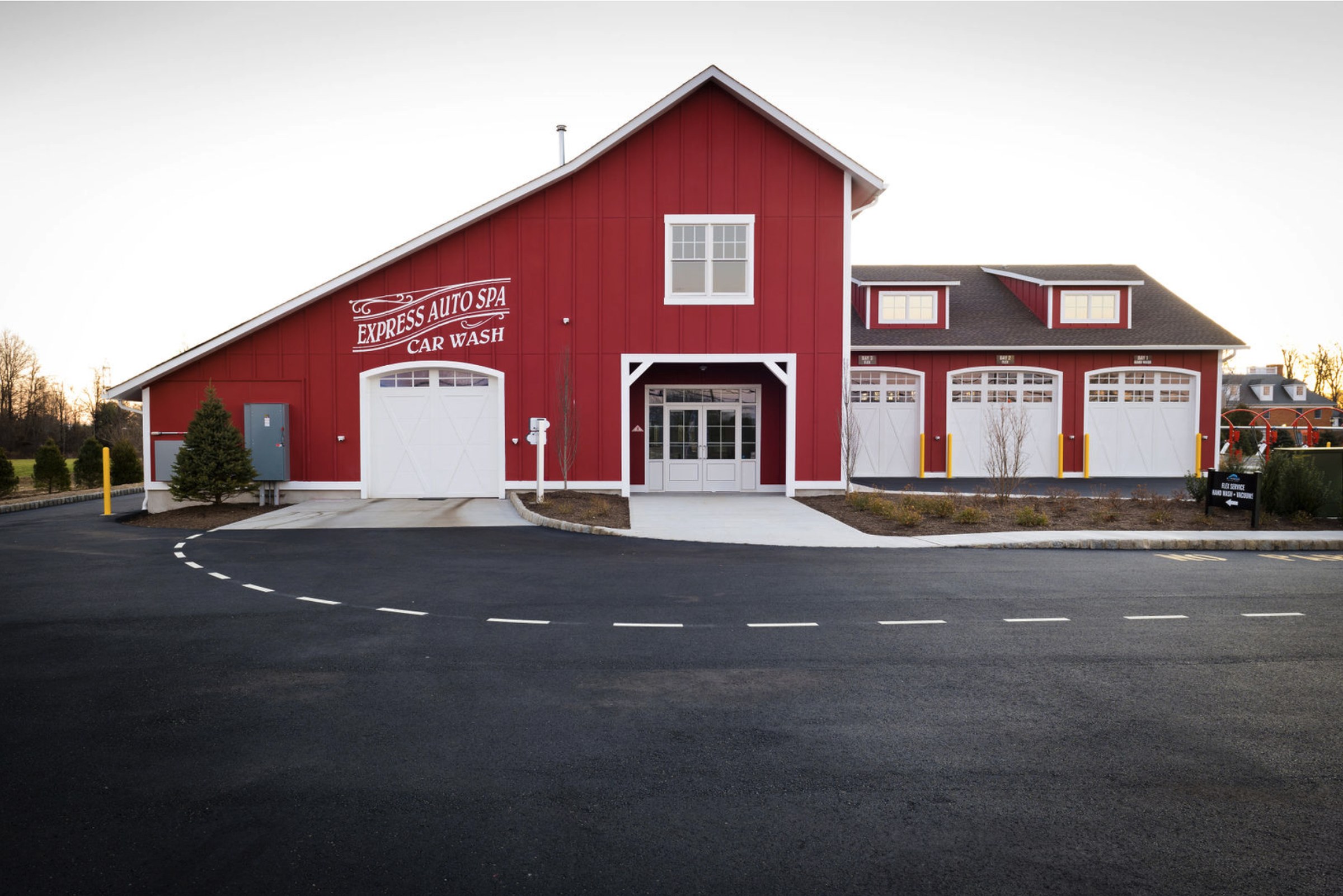 Finished asphalt drive against the red-barn-style facade of Express Auto Spa Colts Neck.