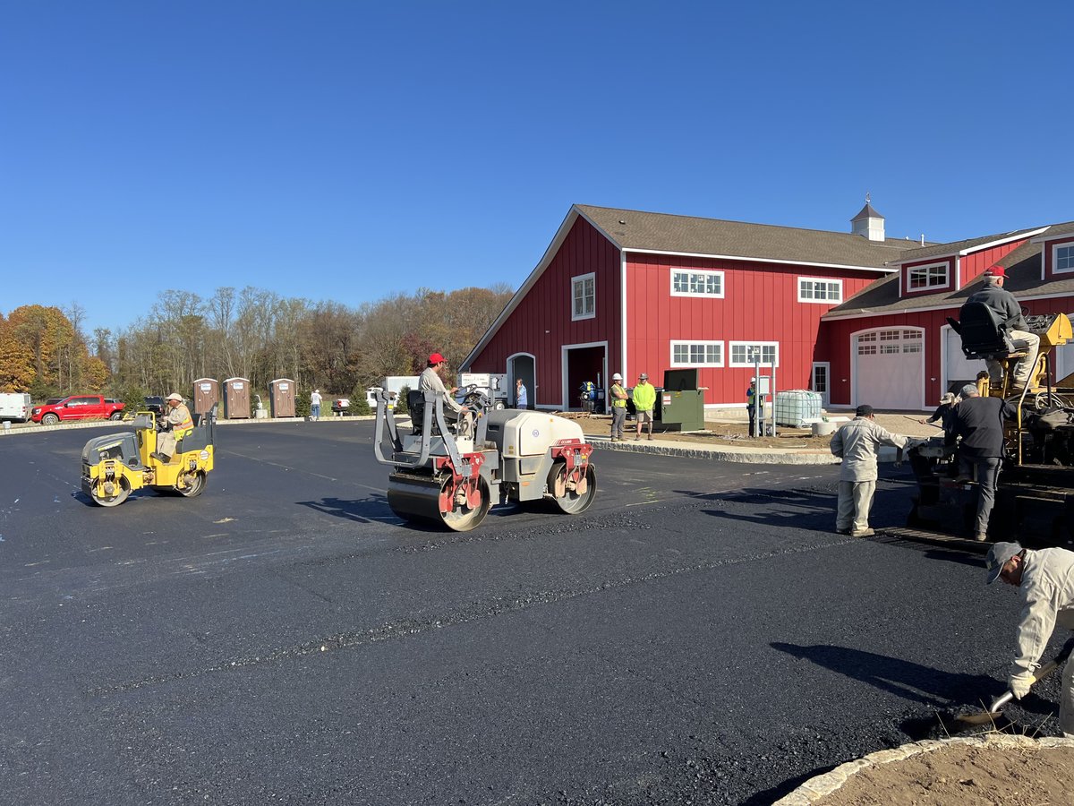 Asphalt rolling against the red-barn facade at Express Auto Spa.