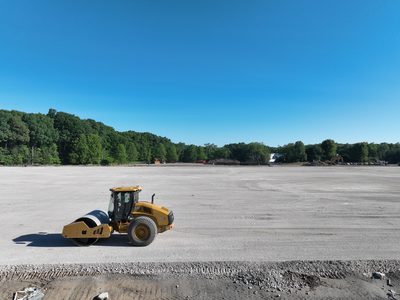 CAT CS13 smooth-drum roller compacting the subgrade on the Parsippany pad.